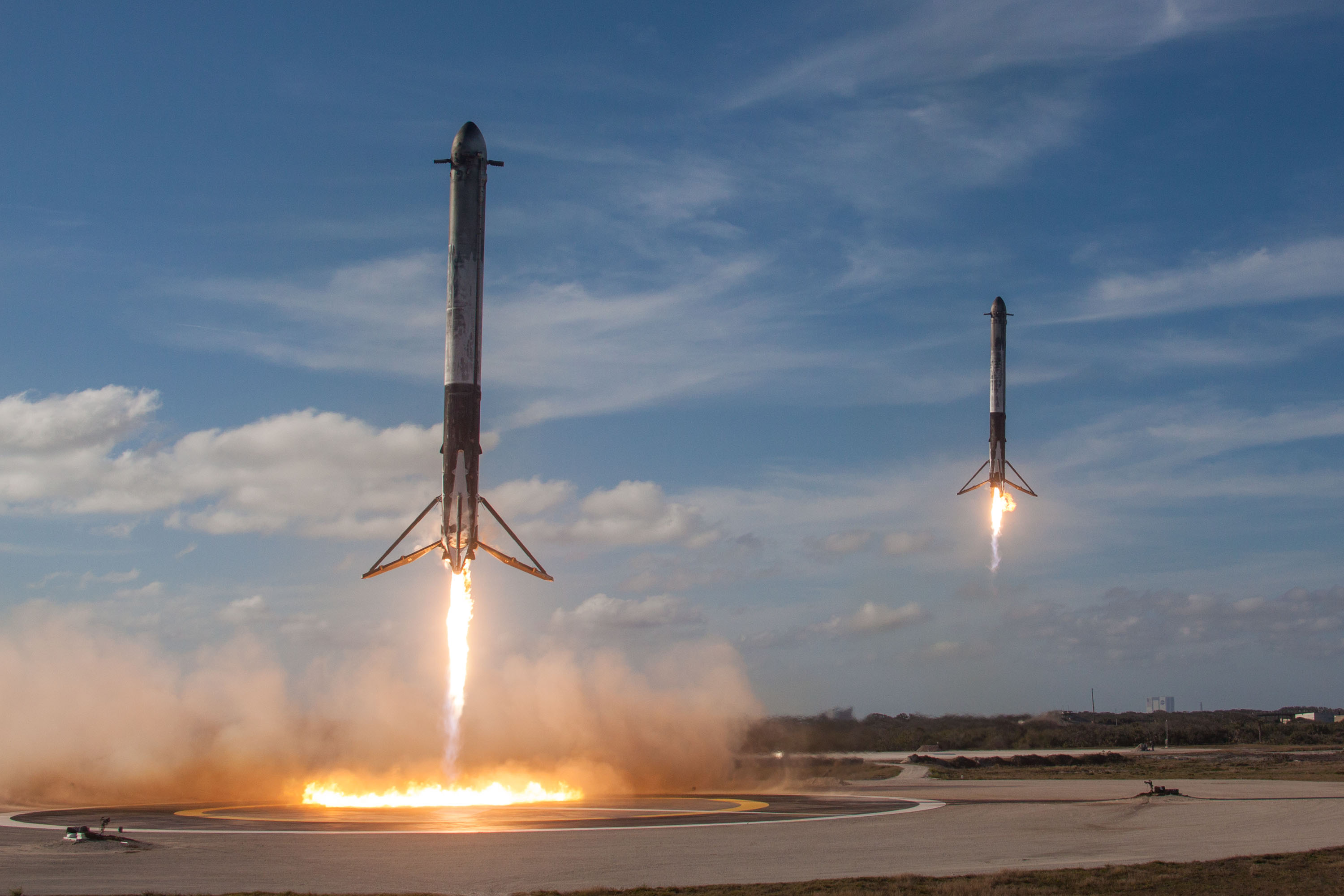 Falcon Heavy side boosters landing in unison, after successfully lofting Starman into orbit